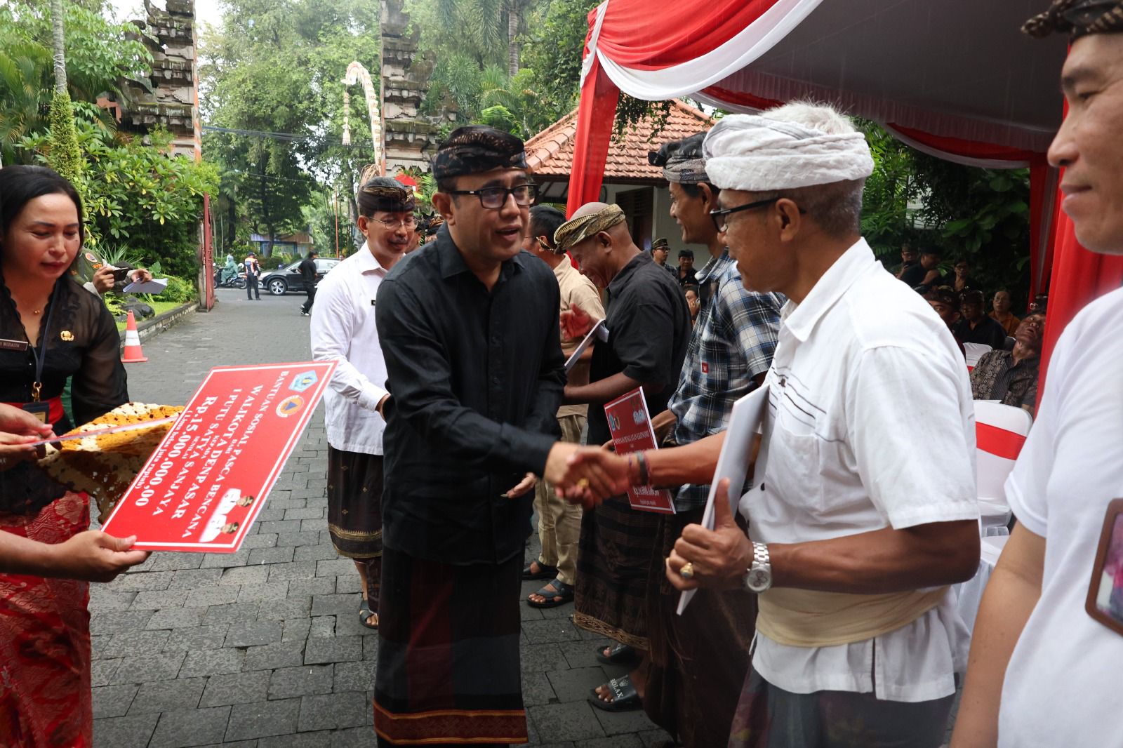 Wali Kota Denpasar, I Gusti Ngurah Jaya Negara saat menyerahkan Bantuan Sosial Pasca Bencana dan Santunan Penguatan Ekonomi Tahap II  di  Kantor Walikota Denpasar Kamis (27/11).