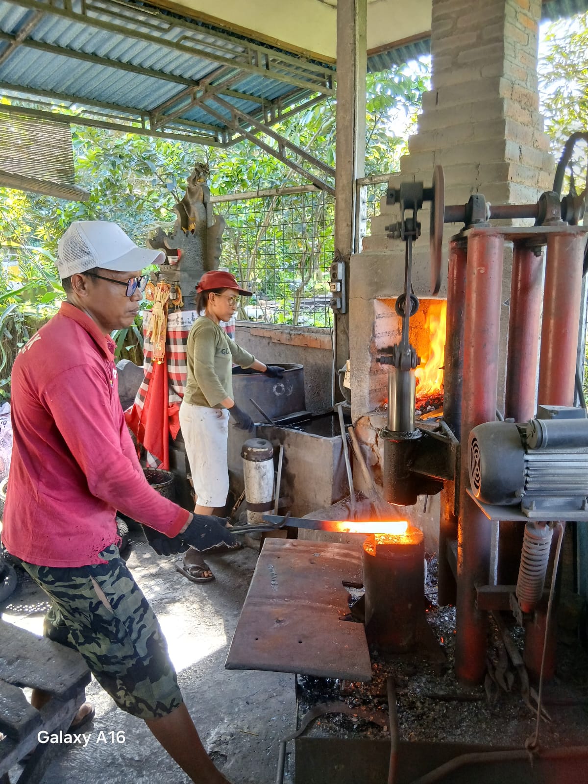 Pengerajin pandai besi, Made Martawan di Dusun Kawanan, Desa Sawan sedang menempa besi yang telah dipanaskan untuk menjadi golok.