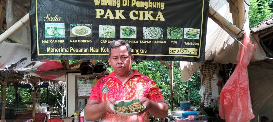 Wayan Sudarta menunjukan menu lawar empas dan minyak empas yang dijualnya di warung miliknya.