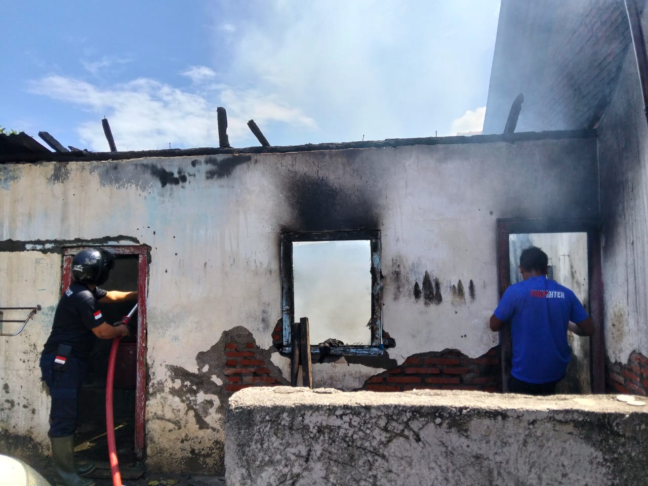 Petugas pemadam kebakaran sedang melakukan pendinginan di lokasi kebakaran.