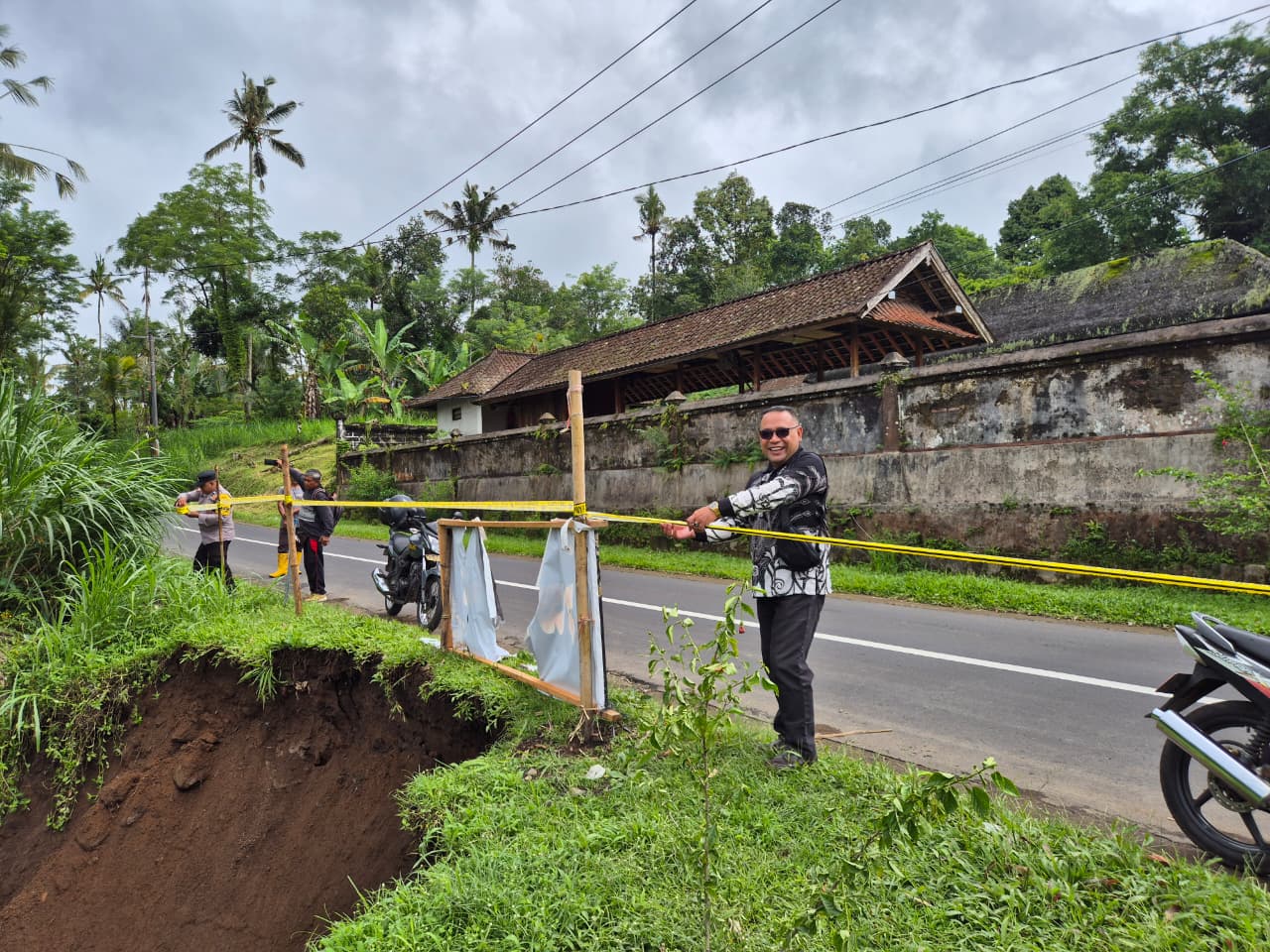 Bahu jalan ambles&nbsp;di&nbsp;Banjar Kembang Merta, Desa Penglumbaran dipasangi police line.