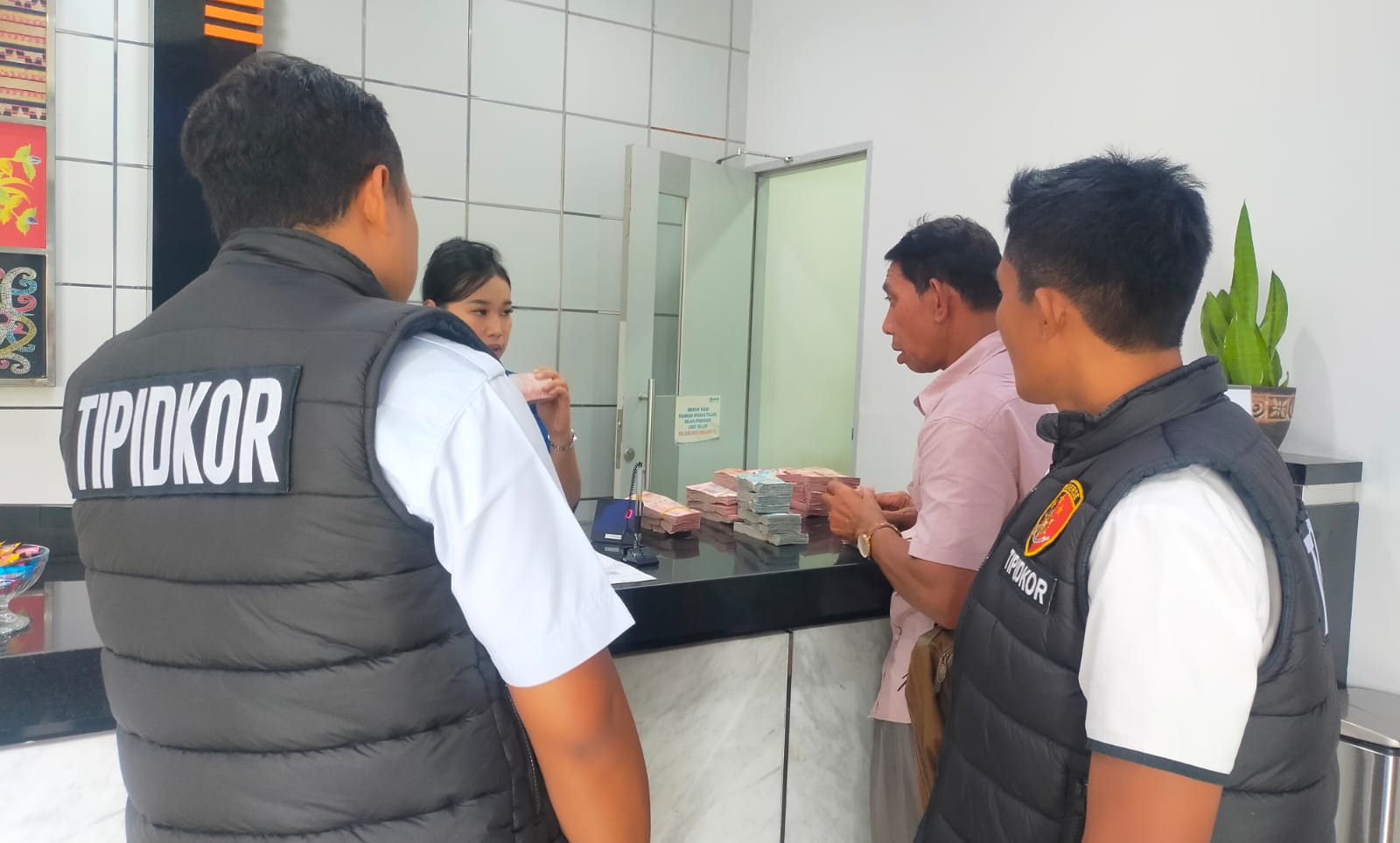 Tipikor Polres Bangli menghitung uang sitaan dari LPD Selulung bersama Ketua LPD yang baru di Wayan Dirka di BRI Bangli, Senin (8/12/2025).