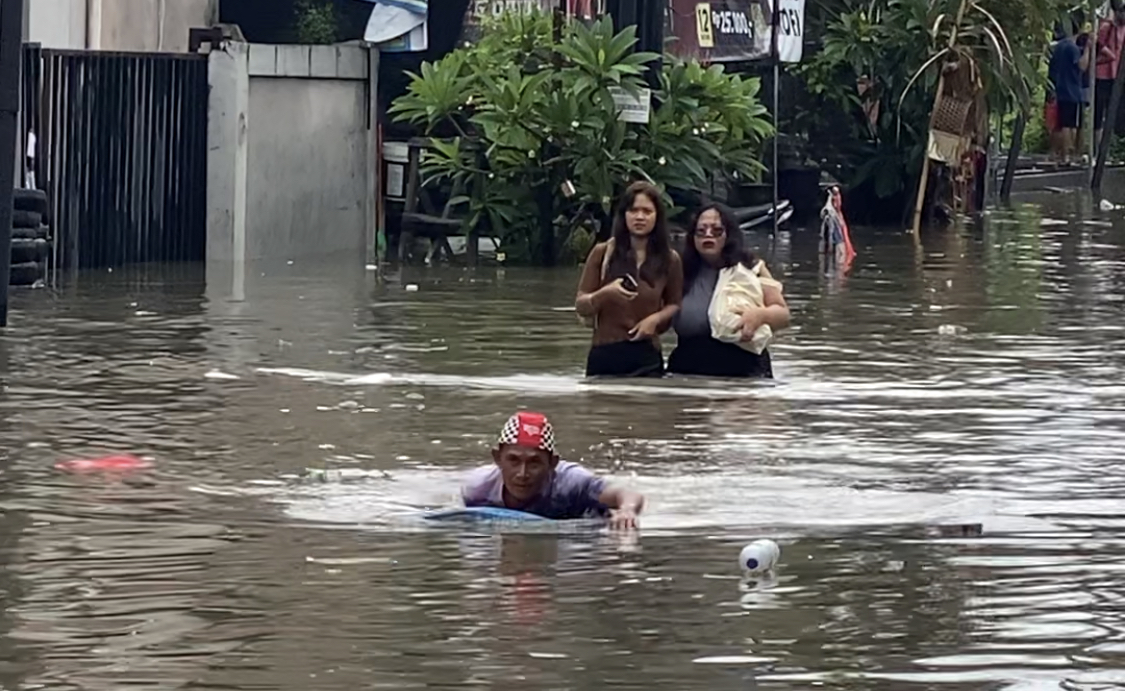 Situasi banjir yang menggenangi Jalan Dewi Sri IV, Kelurahan Legian, Kecamatan Kuta, Minggu (14/12).