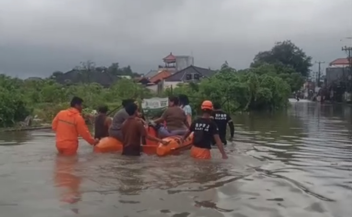 Proses evakuasi menggunakan perahu akibat banjir di Jalan Kunti, Kelurahan Seminyak, Kecamatan Kuta, Minggu (14/12).