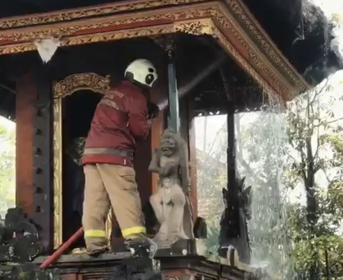 Petugas Diskarmat Badung saat memadamkan api di Pura Karang Buncing, Banjar Sintrig, Desa Sibangkaja, Kecamatan Abiansemal, Minggu (18/1).