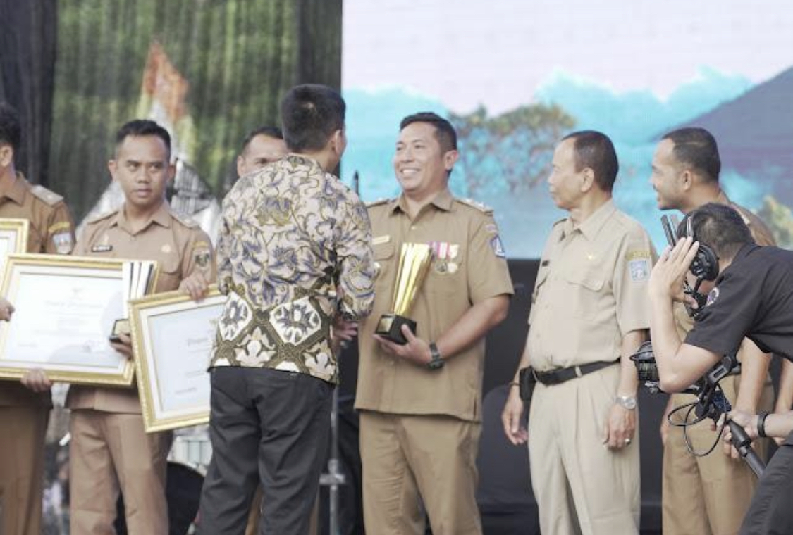 Perbekel Darmasaba, Ida Bagus Surya Prabawa Manuaba saat menerima penghargaan dalam lomba administrasi tata kelola pemerintahan desa, belum lama ini.