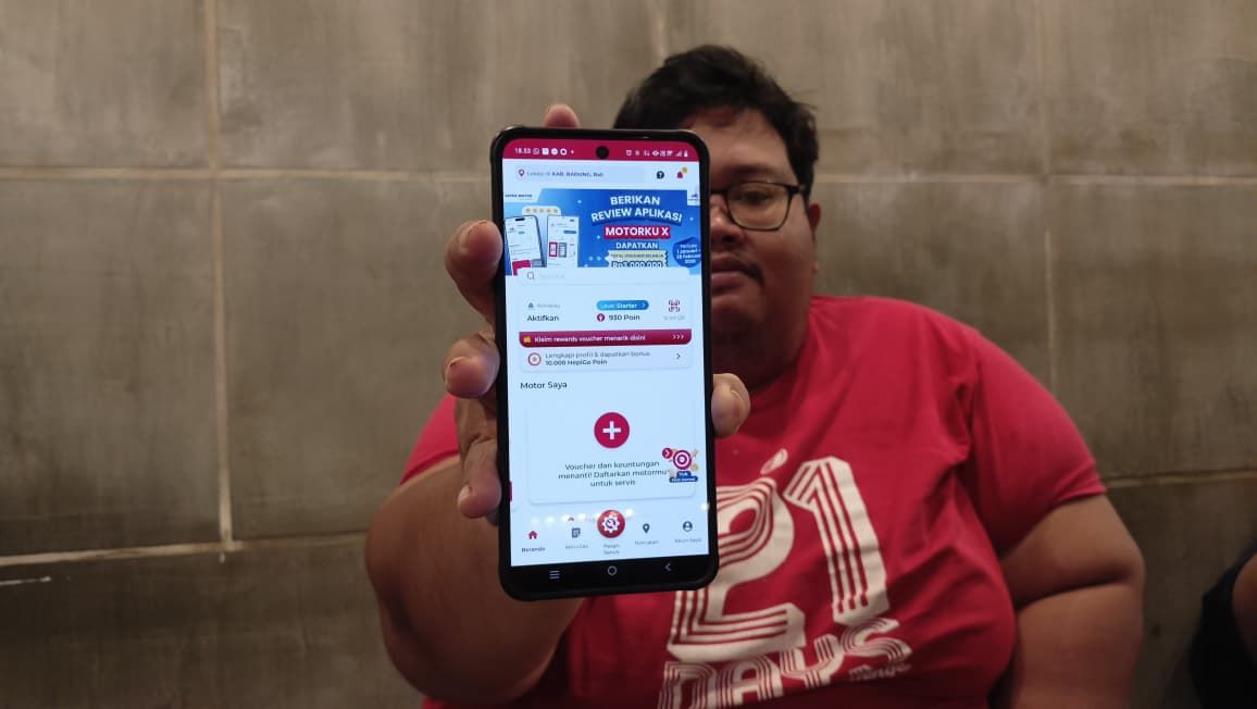 Seorang pelanggan Astra Motor Bali menunjukan aplikasi Motorku X untuk mempermudah akses perawatan sepeda motornya.
