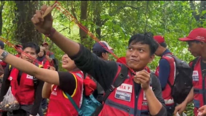 Anggota PMI Bali saat menyebarkan benih menggunakan ketapel di kawasan hutan Desa Batu Agung, Kabupaten Jembrana.
