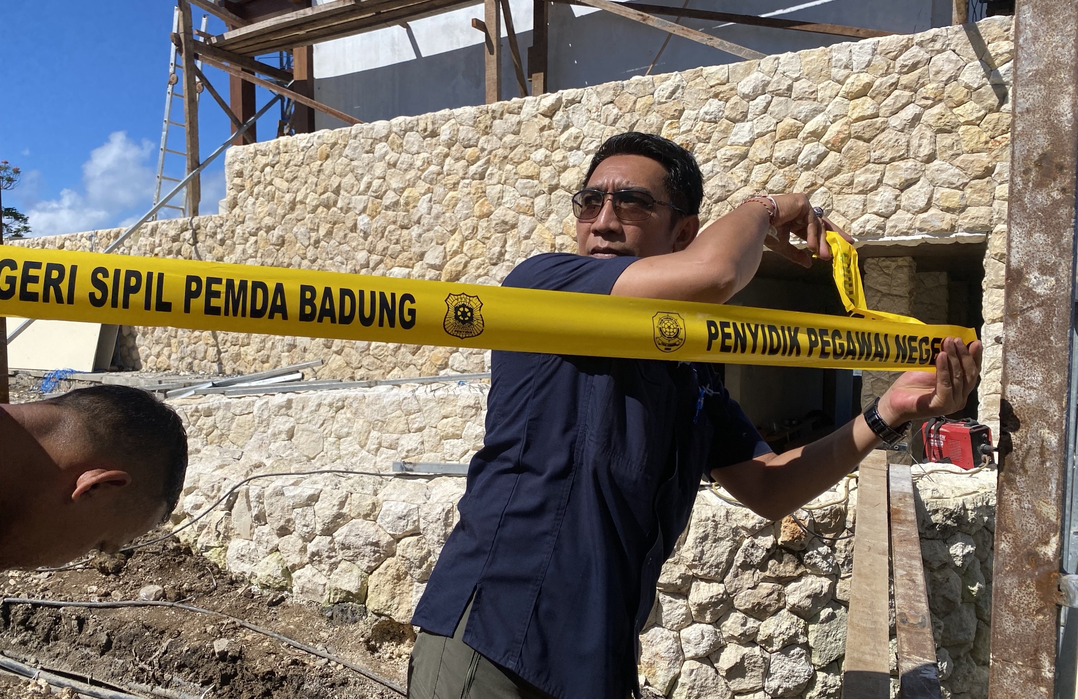 Satpol PP Badung saat memasang Pol PP Line di pembangunan usaha wedding chapel, tebing Pantai Suluban, Desa Pecatu, Kecamatan Kuta Selatan, Selasa (3/2).