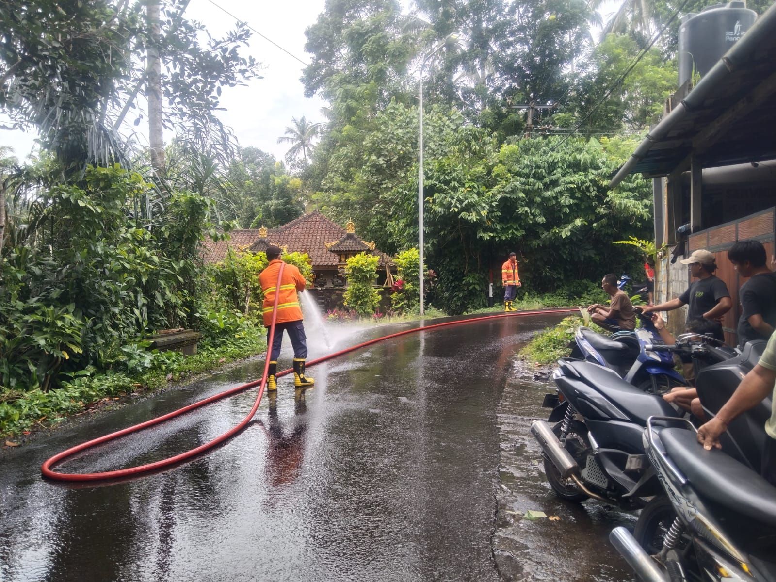 Petugas pemadam kebakaran membersihkan tumpahan solar di Banjar Dinas Tihingseka, Desa Bebandem, Kecamatan Bebandem, Karangasem, Senin (9/2/2026).