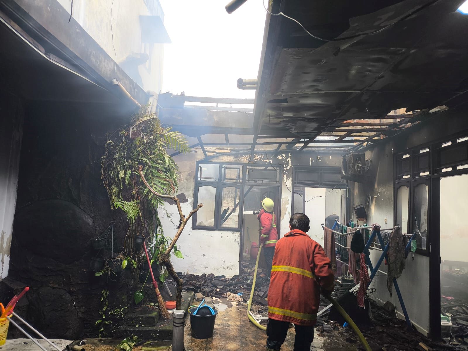 Petugas Damkar Jembrana melakukan pemadaman api yang membakar rumah warga di Banjar Munduk, Desa Pohsanten, Kecamatan Mendoyo, Kabupaten Jembrana, Selasa (17/2/2026).