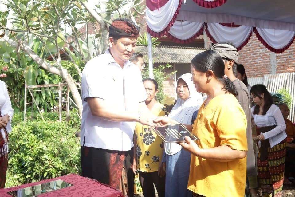 Bupati Jembrana I Made Kembang Hartawan saat menyerahkan bantuan bedah warung milik dadong Luh Sandat, di Desa Tegalbadeng Barat, Jembrana.