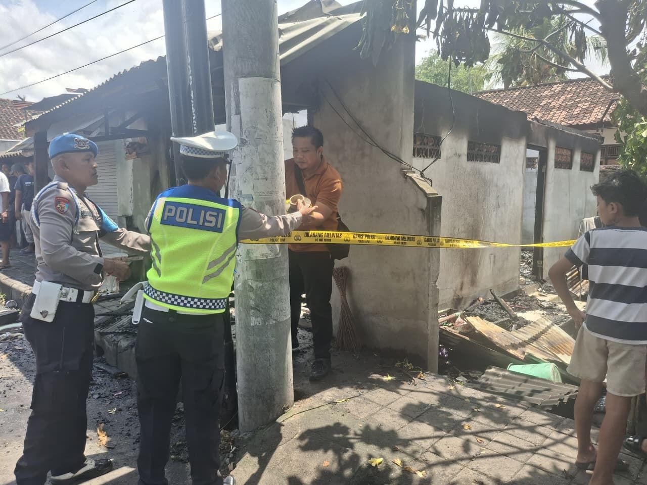 Puing-puing warung nasi di Desa Sangsit, Buleleng usai kebakaran dipasangi garis polisi, Rabu (18/2/2026).