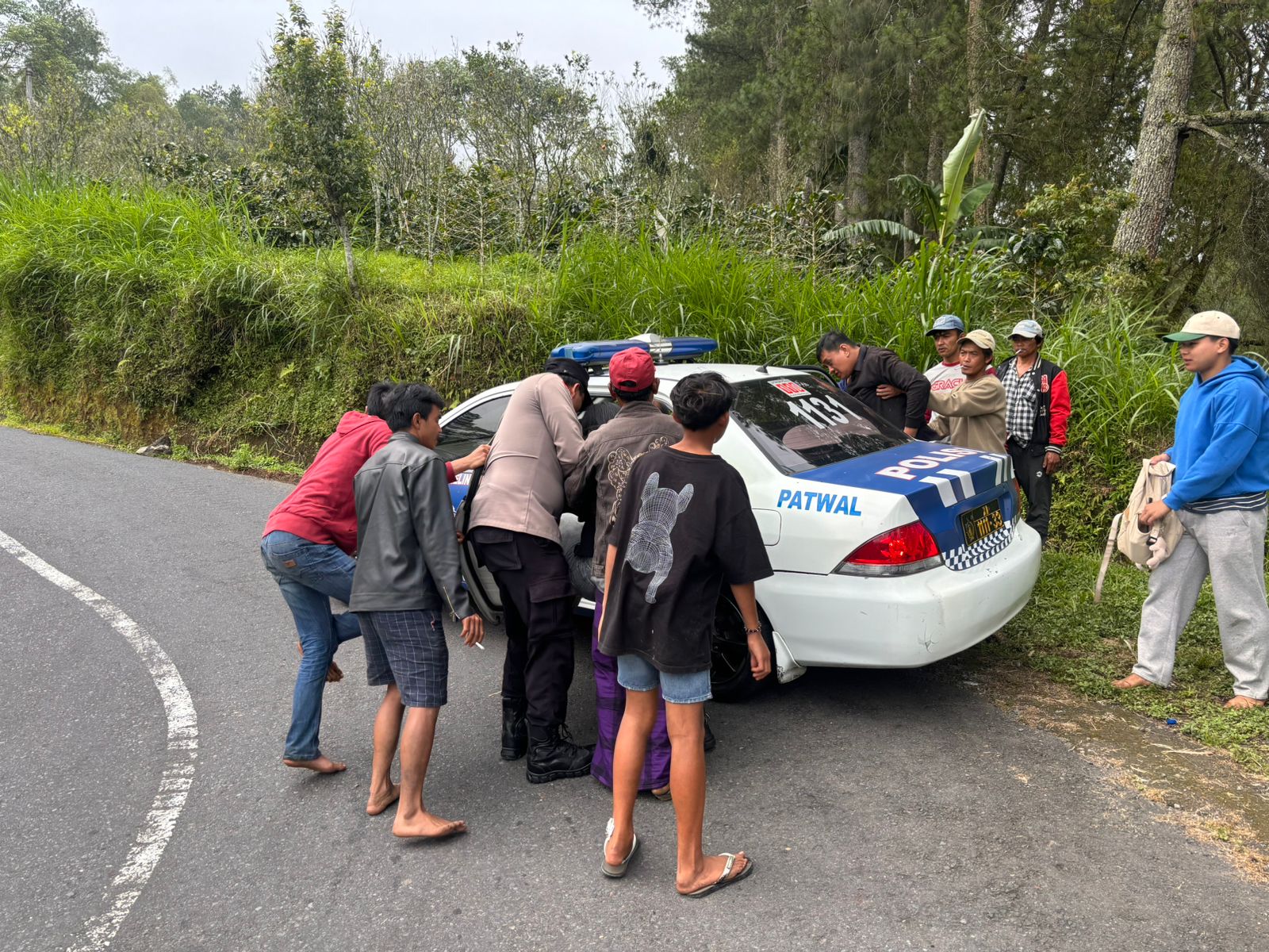Polisi dibantu warga mengevakuasi korban kecelakaan di Jalur Pura Penulisan-Pinggan, Kecamatan Kintamani, Bangli, Rabu (18/2/2026).