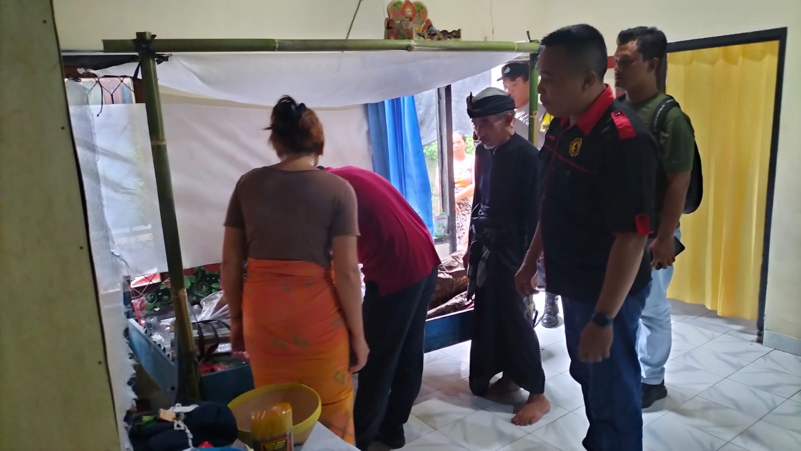 Polisi memeriksa jenazah lansia yang tergantung di dapur rumahnya di Desa Ambengan, Buleleng.