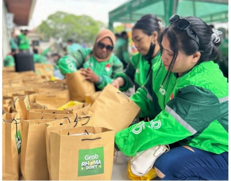 Para Mitra Pengemudi menyiapkan paket takjil untuk dibagikan. Di sela kesibukan mengantar penumpang dan pesanan, Mitra Pengemudi Grab berbagi takjil kepada sesama pengguna jalan dalam kegiatan KOLAK 