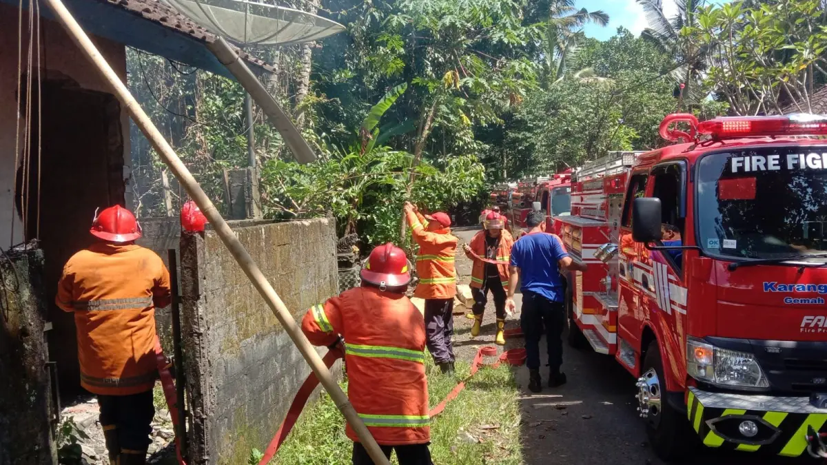 Petugas pemadam kebakaran berupaya memadamkan api di rumah I Wayan Suyasa di Banjar Sekar Gunung, Desa Bukit, Kabupaten Karangasem, Minggu (29/3/2026) siang.