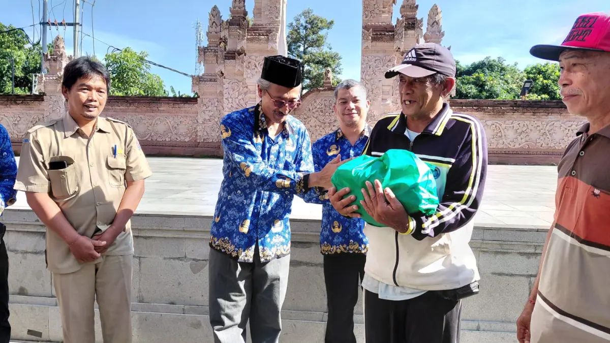 Rektor IAHN Mpu Kuturan, Prof. Dr. I Gede Suwindia, M.A saat menyerahkan puluhan sembako kepada lansia di Banyuning serangkaian Dies Natalis Perdana pada Senin (4/5) pagi 