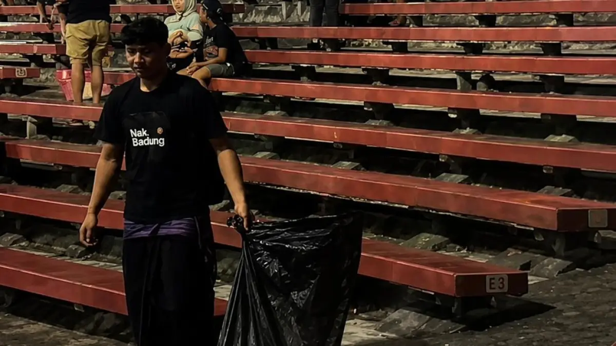 Salah satu purna Paskibraka Badung yang melakukan pembersihan sampah di area Ardha Candra, Taman Budaya Art Center, Denpasar, Minggu (28/6). (Ist)