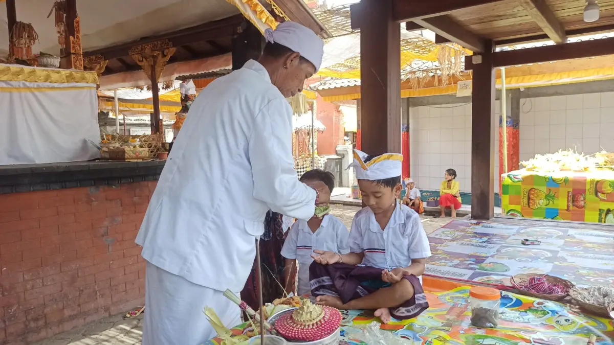 Penggunaan Benang Tebus putih saat otonan yang dilaksanakan hari kelahiran sarat akan makna (I Putu Mardika/Bali Express)