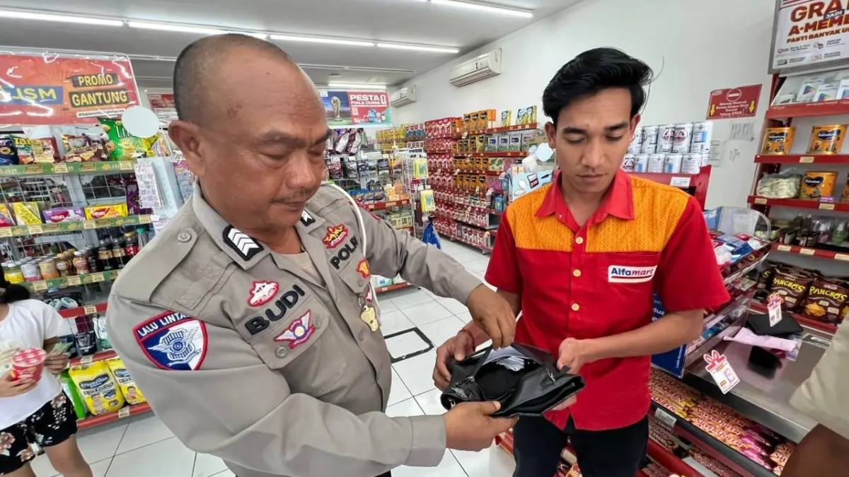 Pegawai Alfamart Banyubiru menunjukkan temuan dompet hitam milik pelanggan yang tertinggal di Alfamart Banyubiru, Kecamatan Negara, Jembrana, Senin (6/7/2026). (Ist)
