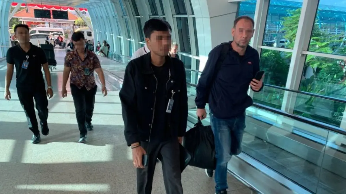 Petugas Rudenim Denpasar mengawal JF (kanan), seorang WNA asal Italia yang dideportasi di Bandara Ngurah Rai, Kabupaten Badung, Bali, Sabtu (25/7/2026). (ANTARA/HO-Rudenim Denpasar)