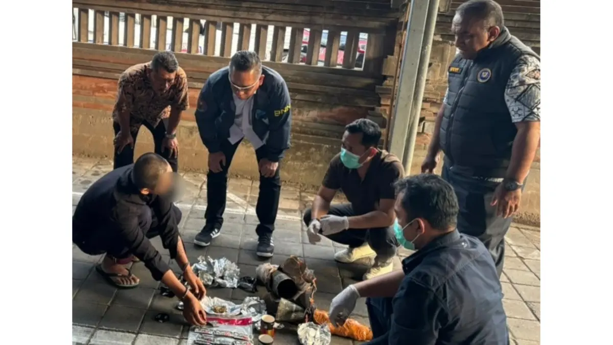 GELEDAH: Penggeledahan paket berisi empat jenis narkoba di hadapan pelaku inisial GAS (Tangan diborgol) di Jalan Taman Pancing, Pemogan, Jumat (31/7). (Bali Express/Istimewa)