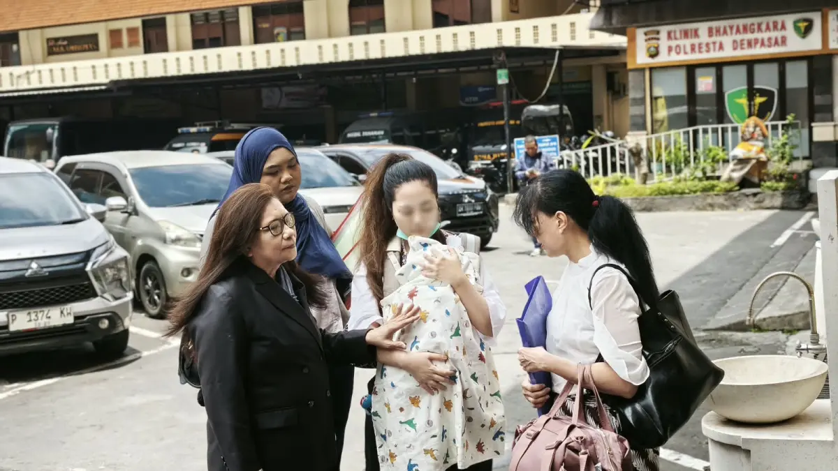 DAMPINGI: Ipung (jas hitam) mendampingi KC (menggendong bayi) dan ibunya LJL menghadiri panggilan pemeriksaan sebagai tersangka di Polresta Denpasar. (Bali Express/I Gede Paramasutha)
