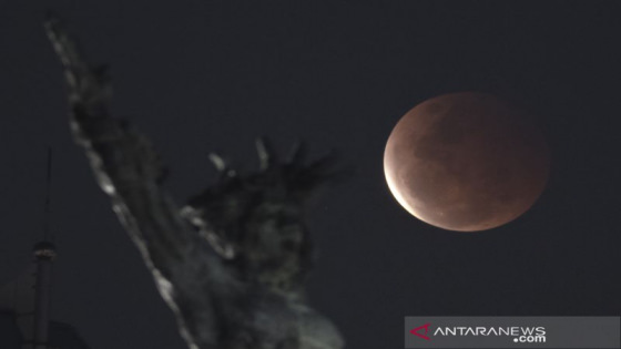 ILUSTRASI : Fase gerhana bulan total terlihat dengan latar depan tugu pembebasan Irian Barat di Lapangan Banteng, Jakarta, Rabu (26/5/2021). Antara/Wahyu Putro