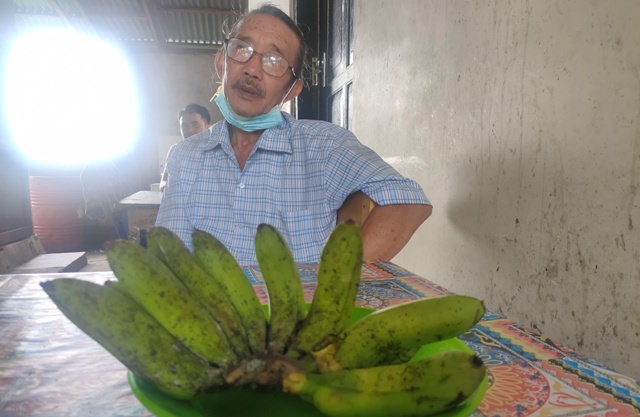 BIU BUNGA: Pemangku Desa Tigawasa, Jro Mangku Ketut Sudaya dan biu bunga. (DIAN SURYANTINI/BALI EXPRESS)