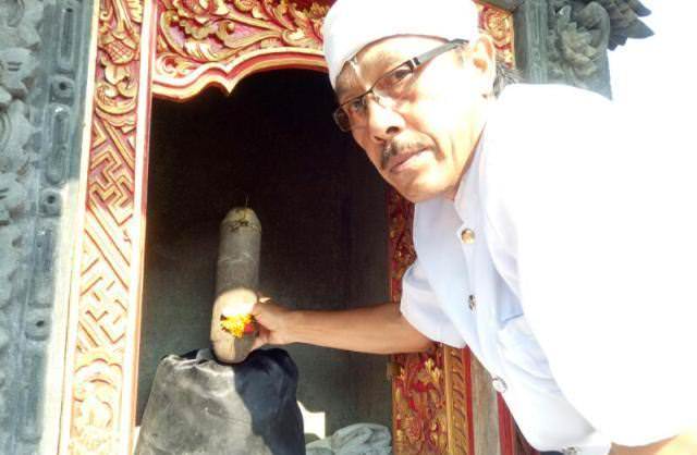 PALINGGIH: Jero Mangku Made Mesin saat menunjukkan Palinggih Dewa Gede Celak Kontong berbentuk kelamin sebagai simbol lingga yoni. (I PUTU MARDIKA/BALI EXPRESS)