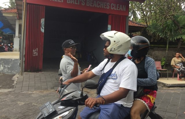 RAMAH: Tibor (kiri) saat memungut retribusi parkir dengan ramah dari pengunjung pantai Legian, Kamis (20/1). (PUTU RESA KERTAWEDANGGA/BALI EXPRESS)