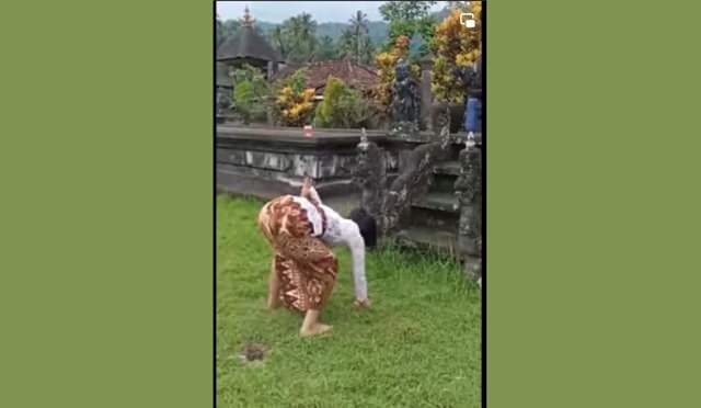 MENARI: Terlihat di video di akun @infoberitabali, Komang Trisna Wati kerauhan di jaba Pura Bale Agung, Desa Selumbung, Manggis. (tangkapan layar video)
