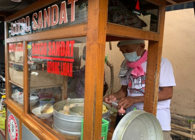BERJUALAN: Painten bersama sang istri, Tijah, yang ditemui di lokasi saat melayani pelanggan baksonya di kawasan Jalan Sandat, Banjar Kertha Bhuwana Kaja, Dangin Puri Kangin, Denpasar Utara. (RIKA RIYANTI/BALI EXPRESS)