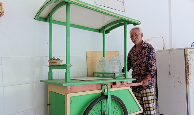 GEROBAK ES PUTER: Nyoman Suda, kakak almarhum Ketut Sudi, memperlihatkan gerobak es puter milik sang ayah yang dipakai berjualan pada 1960-an. (AGUS EKA PURNA NEGARA/BALI EXPRESS)