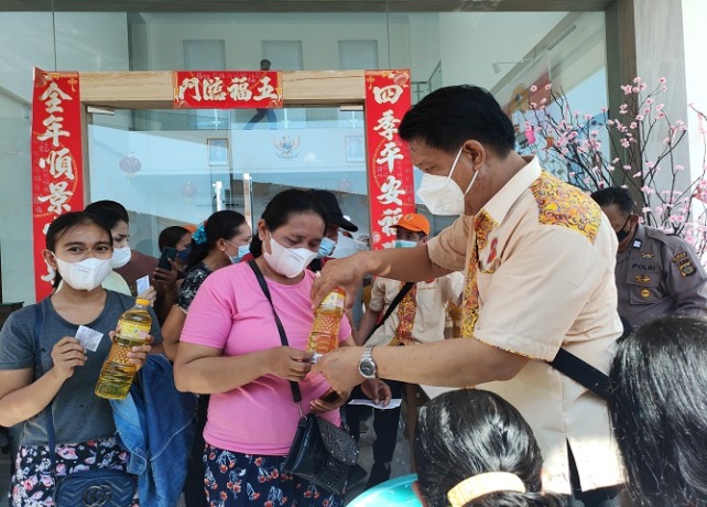 HADIAH: Pembagian minyak goreng kepada warga yang telah mengikuti vaksinasi booster. (I GEDE PARAMASUTHA/BALI EXPRESS)