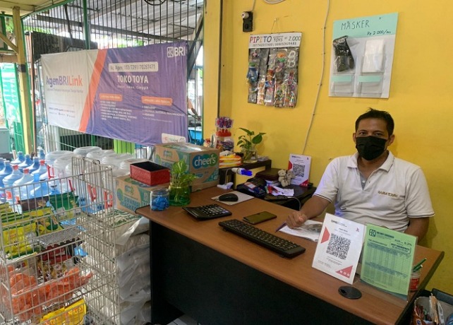 MUDAH: Salah seorang AgenBRILink di Jalan Letda Kajeng, Dangin Puri Klod, Denpasar Timur, I Nyoman Wisnaya Putra. RIKA RIYANTI/BALI EXPRESS)