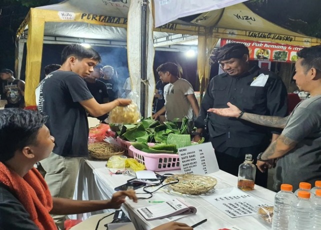 TETAP BERJALAN : Bendesa Adat Kesiman, I Ketut Wisna (dua dari kanan) menyambangi stand kuliner saat kegiatan musik di Taman Bali Festival, Padang Galak, Kesiman, Sabtu (24/4). (ISTIMEWA)