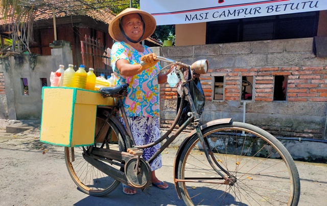GIGIH: Mbah Jumilah saat berjualan jamu di Jalan Kemuning, Kota Singaraja. (DIAN SURYANTINI/BALI EXPRESS)