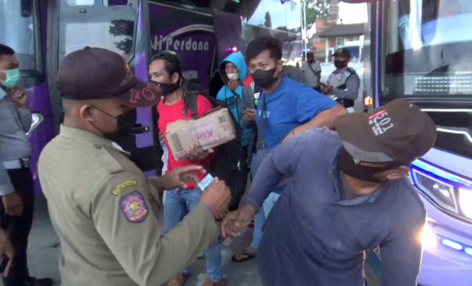 SIDAK: Sejumlah petugas memeriksa identitas para penduduk pendatang yang baru turun di Terminal Tipe A Mengwi. (Agung Bayu/Bali Express)