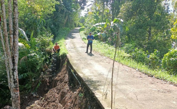 AMBLAS : Senderan rabat beton yang amblas pasca hujan lebat, Selasa (21/6). (I Gde Riantory/Bali Express)