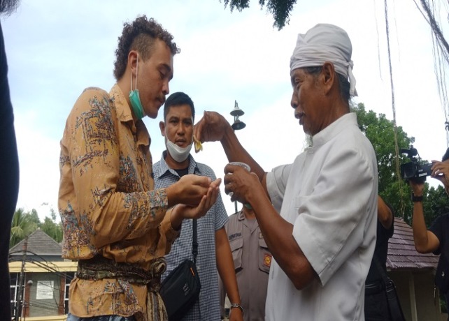 MERERESIK : Bule Konten Asal Australia, Samuel Lockton datang ke lokasi Beringin yang dipanjatnya di Banjar Dakdakan Desa Abian Tuwung Senin (13/6), untuk menyaksikan prosesi upacara mereresik yang dilakukan oleh prjuru adat dan pemangku pura. (IGA KUSUMA