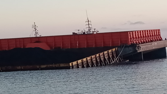 DIPINDAH : Proses pemindahan batu bara dari kapal tongkang yang miring di laut Celukan Bawang, Buleleng. Ist