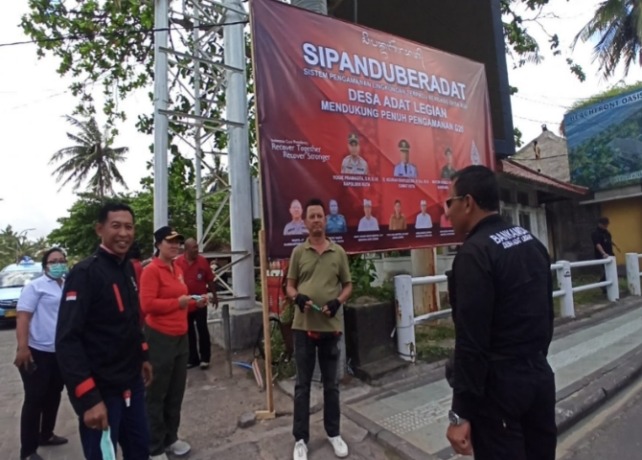 DIPASANG: Pemasangan spanduk Sipanduberadat sebagai dukungan pengamanan G20 di Legian, Rabu (14/9). (Istimewa)