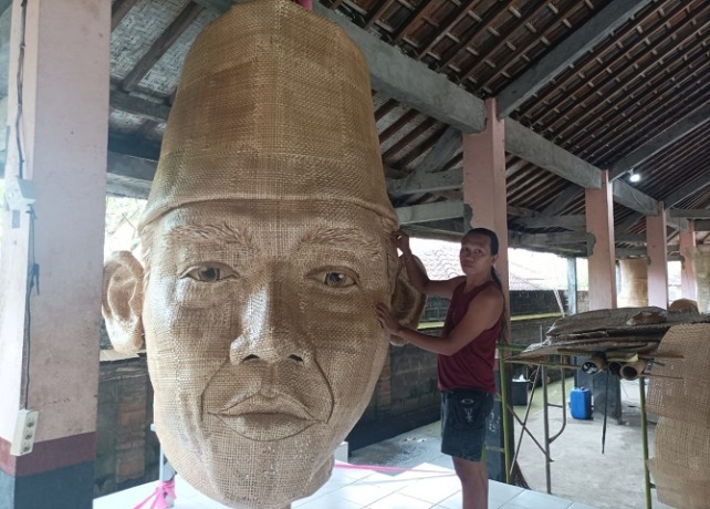 KARYA SENI : Seniman asal Banjar Kelingkung, Desa Lodtunduh, Kecamatan Ubud, Gianyar, I Wayan Agus Eri Putra, 36, bersama potongan patung Bung Karno yang terbuat dari anyaman bambu, Minggu (4/9). (DEWA RASTANA/BALI EXPRESS)
