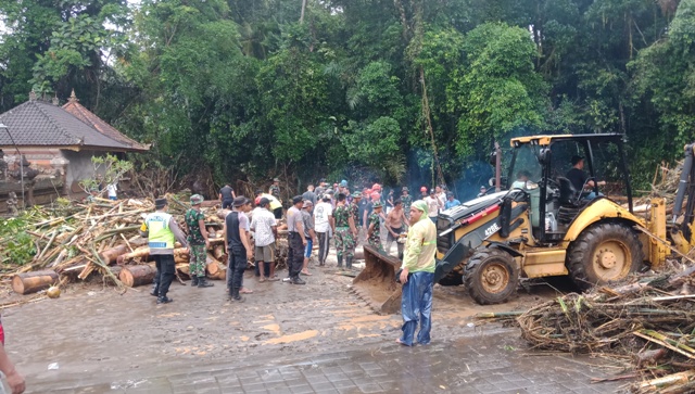 BENCANA: Aktivitas membersihkan material kayu yang terbawa aliran Tukad Yeh Sungi di Tabanan, dengan menggunakan alat berat dan dibantu warga. Diperkirakn berat material.mencapai 50 ton lebih. (ISTIMEWA)