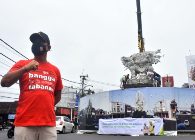 DIPASANG : Proses pemasangan bagian badan dari patung Wisnumurti di perempatan Kediri,Kabupaten Tabanan. (AGUNG BAYU/BALI EXPRESS)