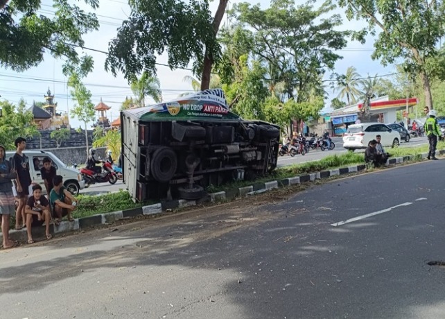 TERGULING : Kondisi mobil truk box yang tergyling setelah terlibat kecelakaan lalu lintas di Jalan Bypass Ida Bagus Mantra, Rabu (19/1). (ISTIMEWA)
