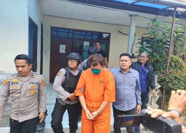 DIRINGKUS: IZ hanya bisa tertunduk lesu saat kasusnya dibeberkan di Mapolsek Densel. (I GEDE PARAMASUTHA/BALI EXPRESS)