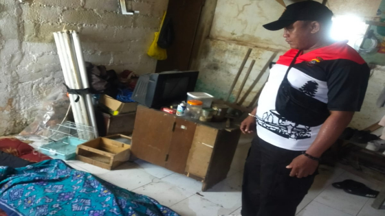 RUMAH : Korban ditutup selimut. Polisi telah memasang police line di pagar rumah Juniarta. Ist